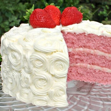 Sliced strawberry layer cake on pedestal