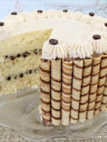 Cannoli cake, sliced, on a cake pedestal.