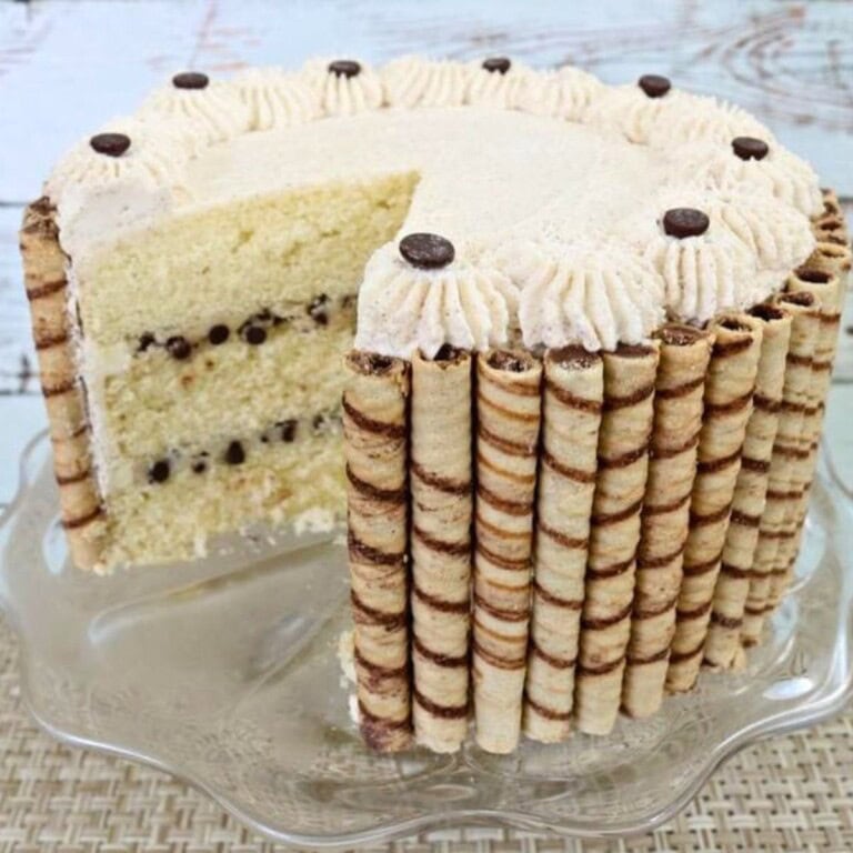 Cannoli cake, sliced, on a cake pedestal.