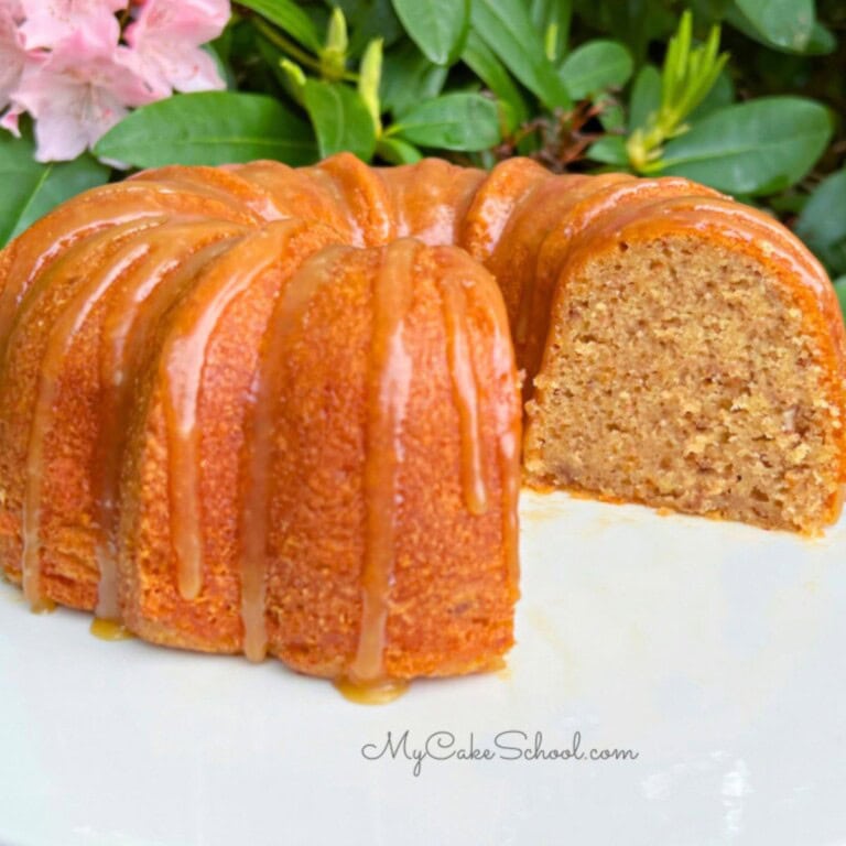 Banana Pecan Bundt Cake, sliced, on a cake pedestal.