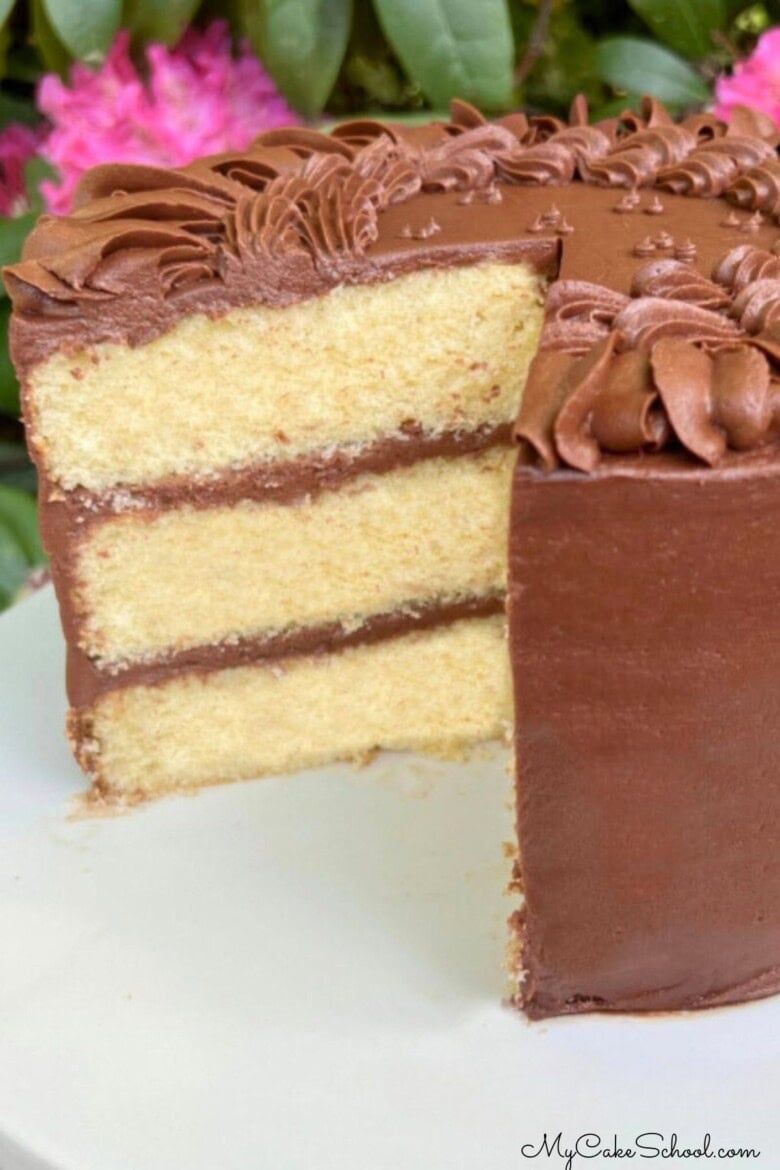 Yellow Birthday Cake, sliced, on a cake pedestal.