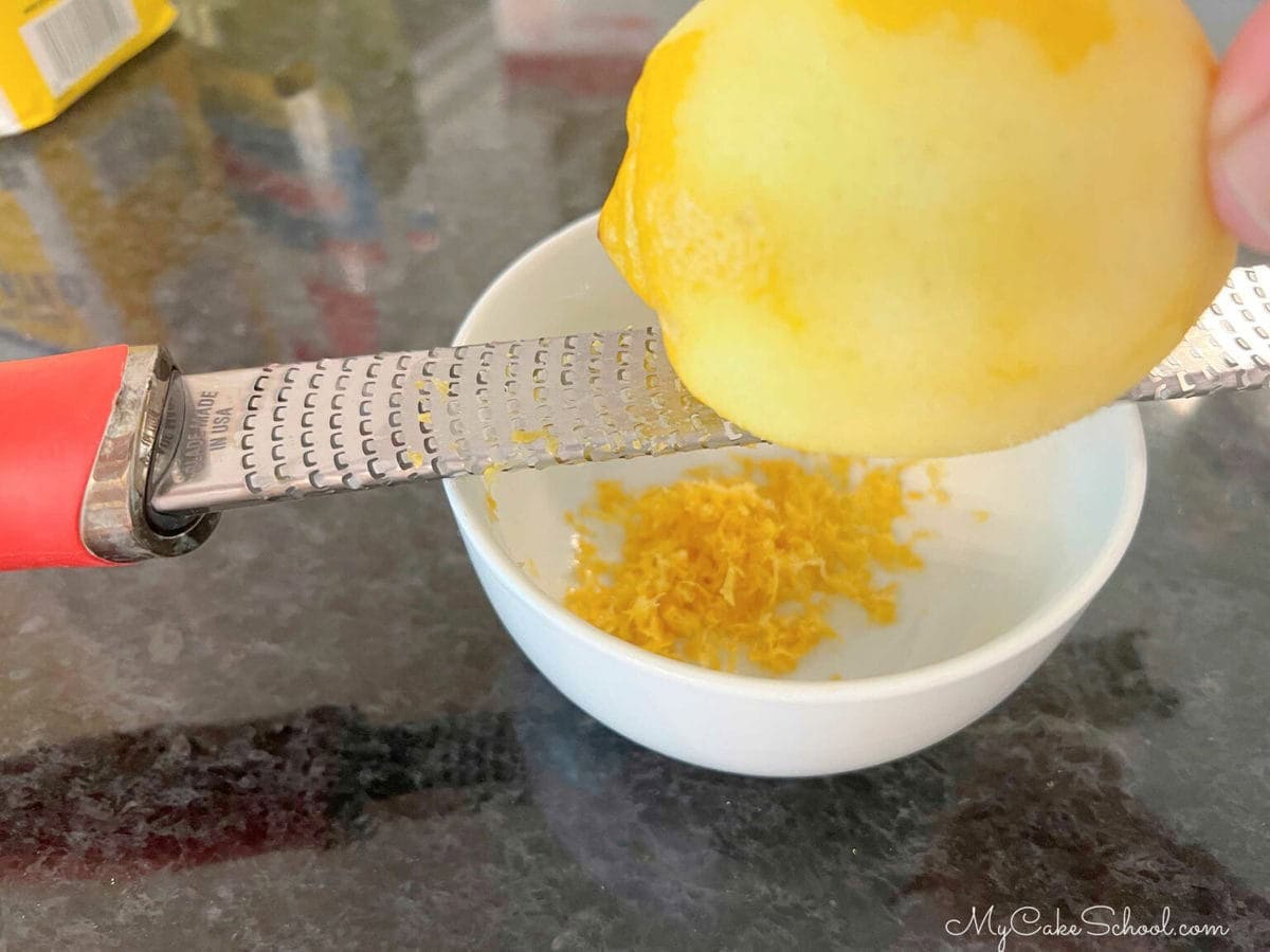 zesting lemon into a bowl.