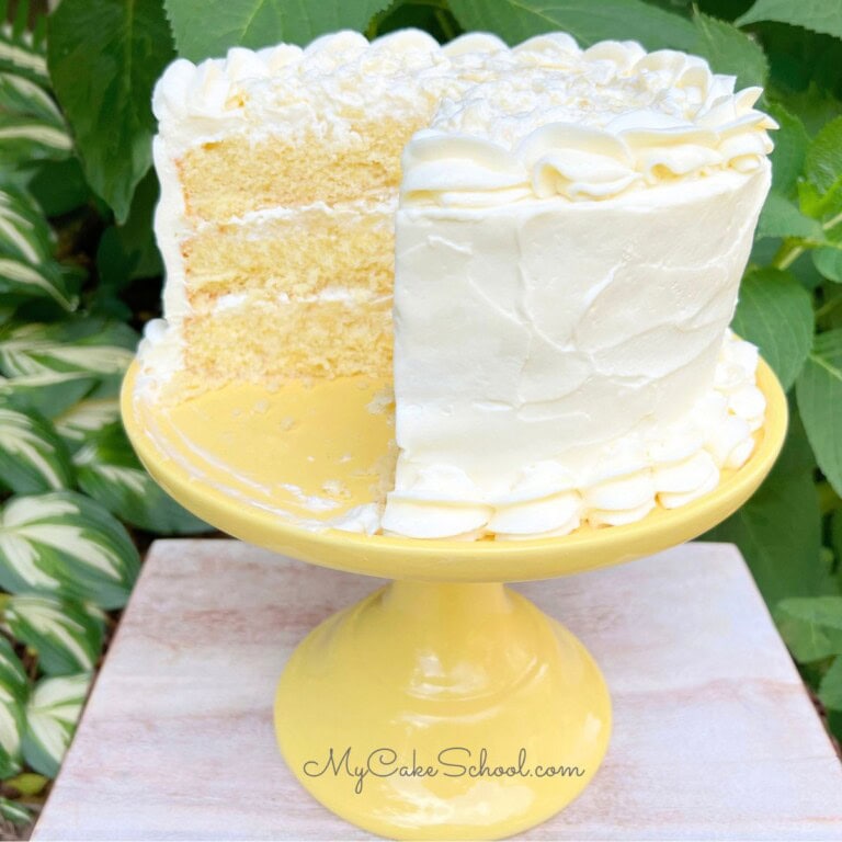 Moist Pineapple Dream Cake, sliced, on a cake pedestal.