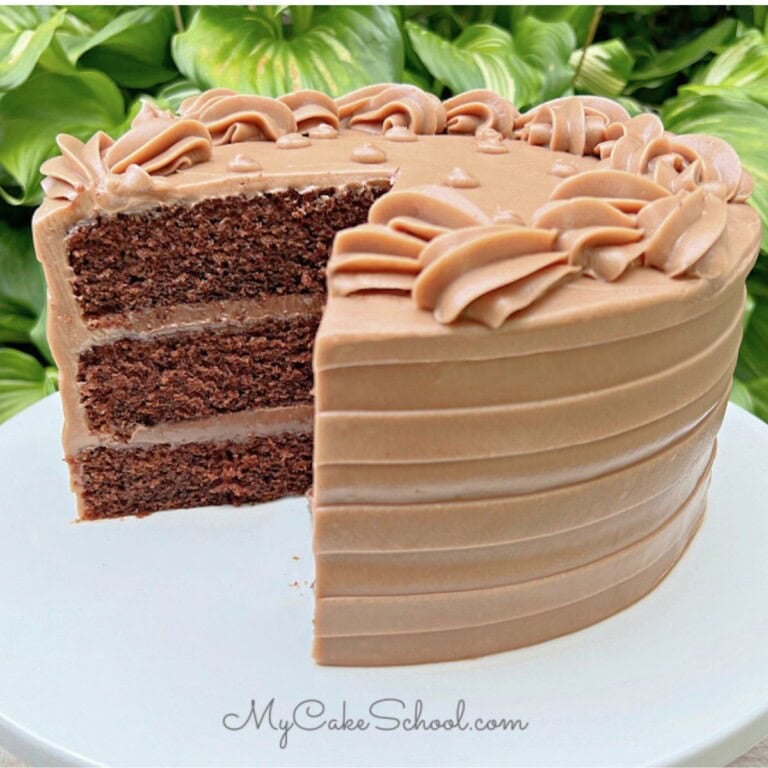 Moist Chocolate Cream Cake, sliced, on a cake pedestal.