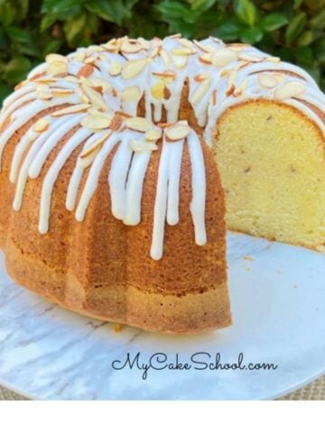 Almond Sour Cream Pound Cake, sliced, on a cake pedestal.