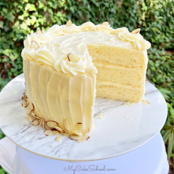 Lemon Almond Cake, sliced, on a pedestal.