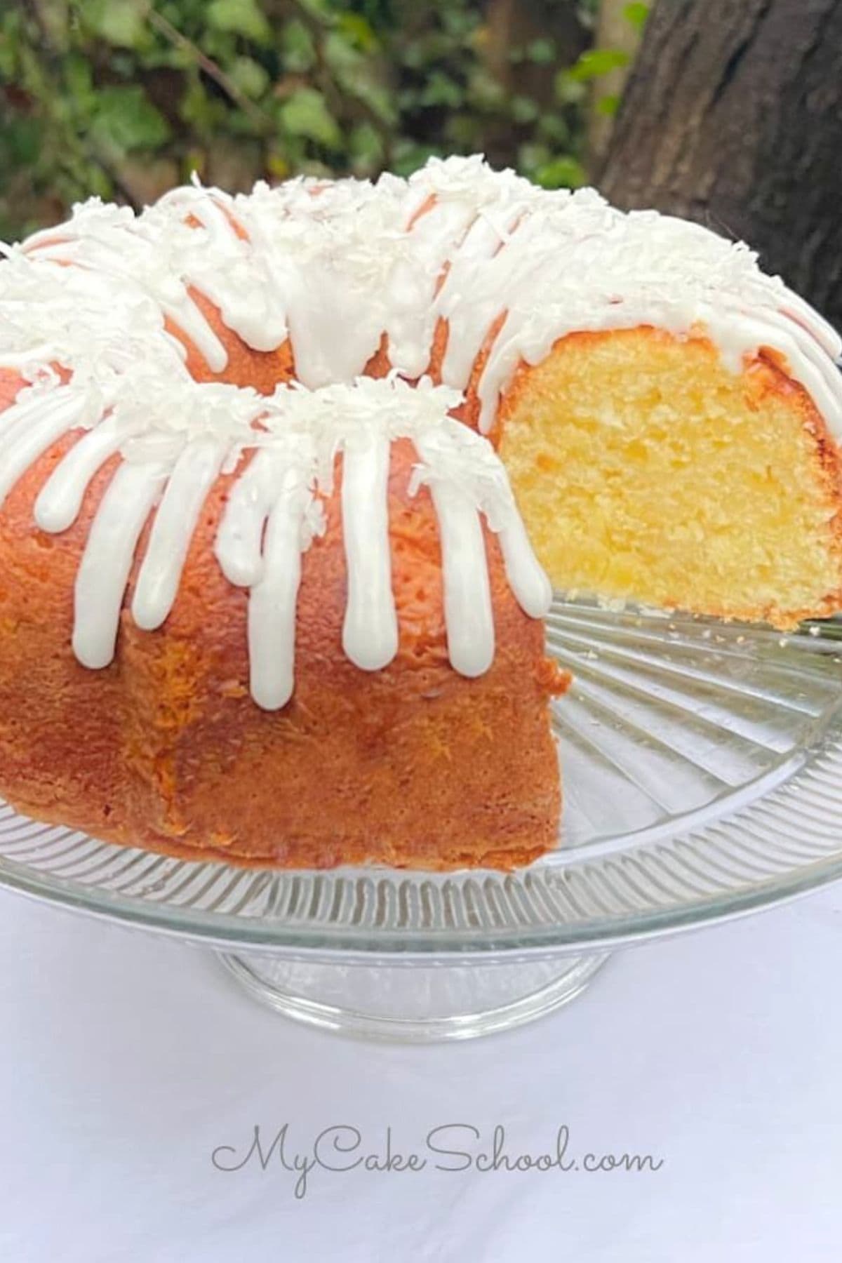 Pineapple Coconut Pound Cake, sliced, on a cake pedestal.