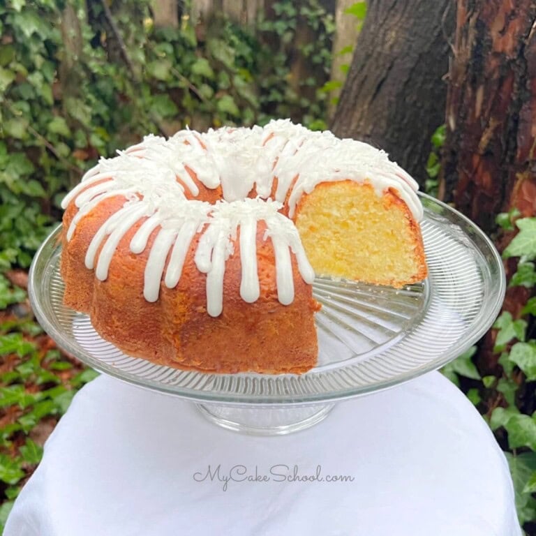 Pineapple Coconut Pound Cake, sliced, on a cake pedestal.