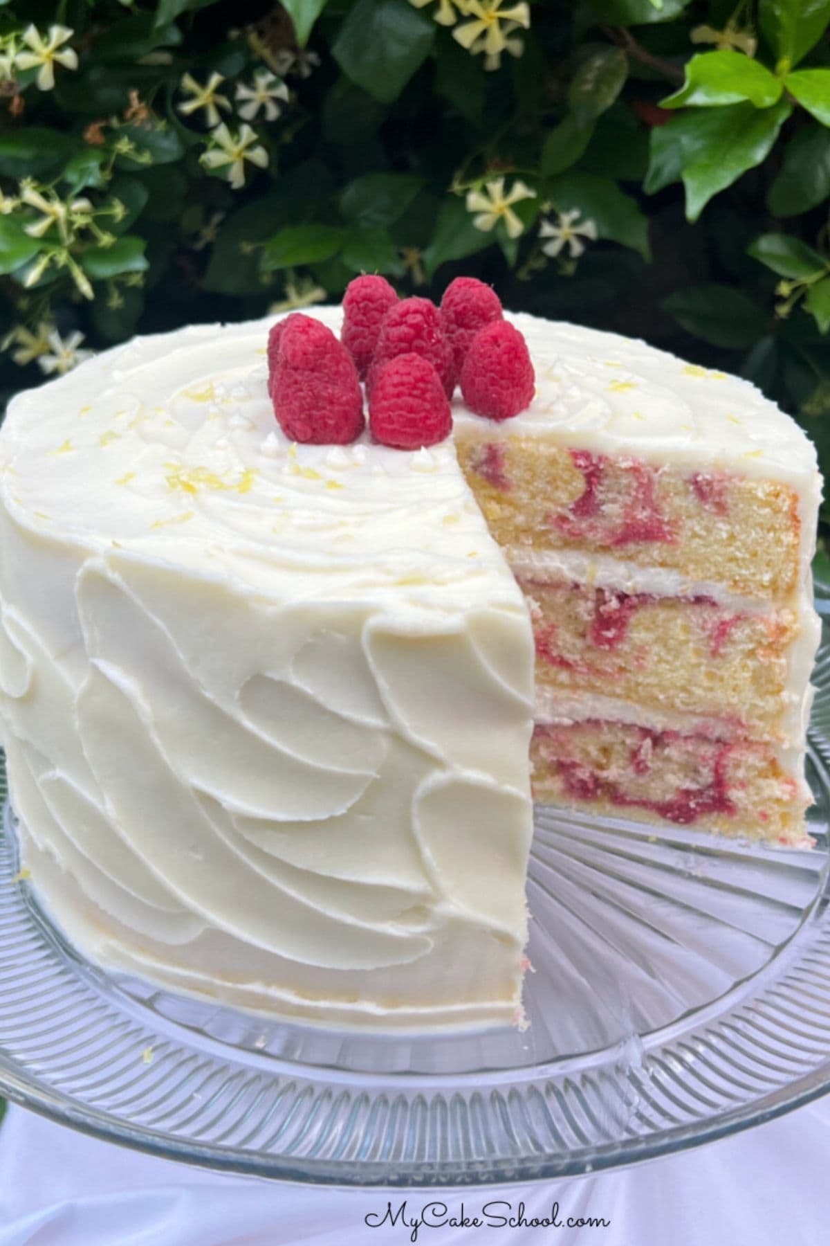 Lemon Raspberry Swirl Cake, sliced, on a pedestal.