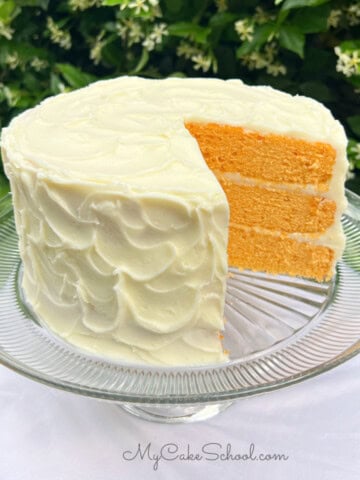 Orange Vanilla Bean Cake, sliced, on a cake pedestal.