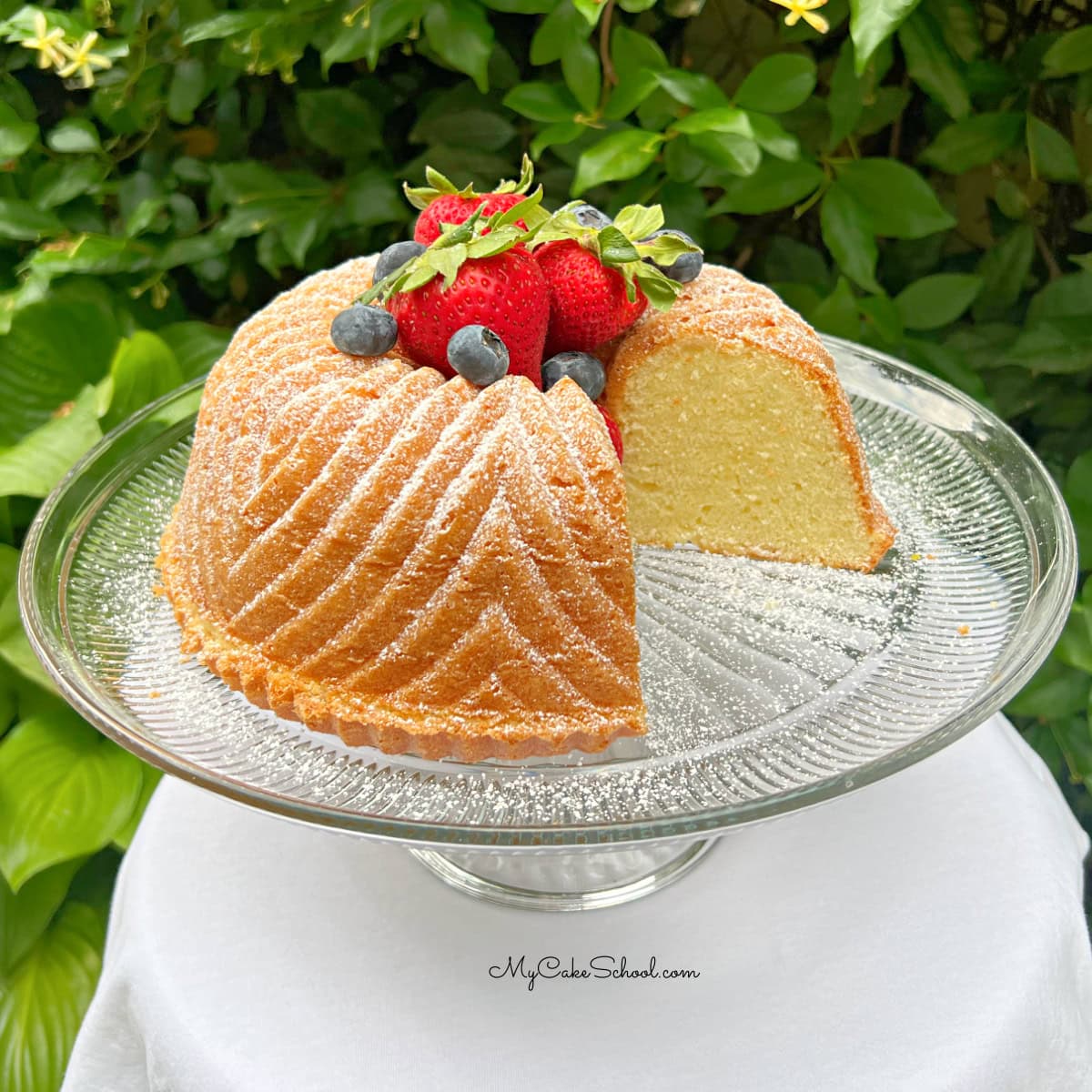 Vanilla Bundt Cake, sliced, on a cake pedestal.