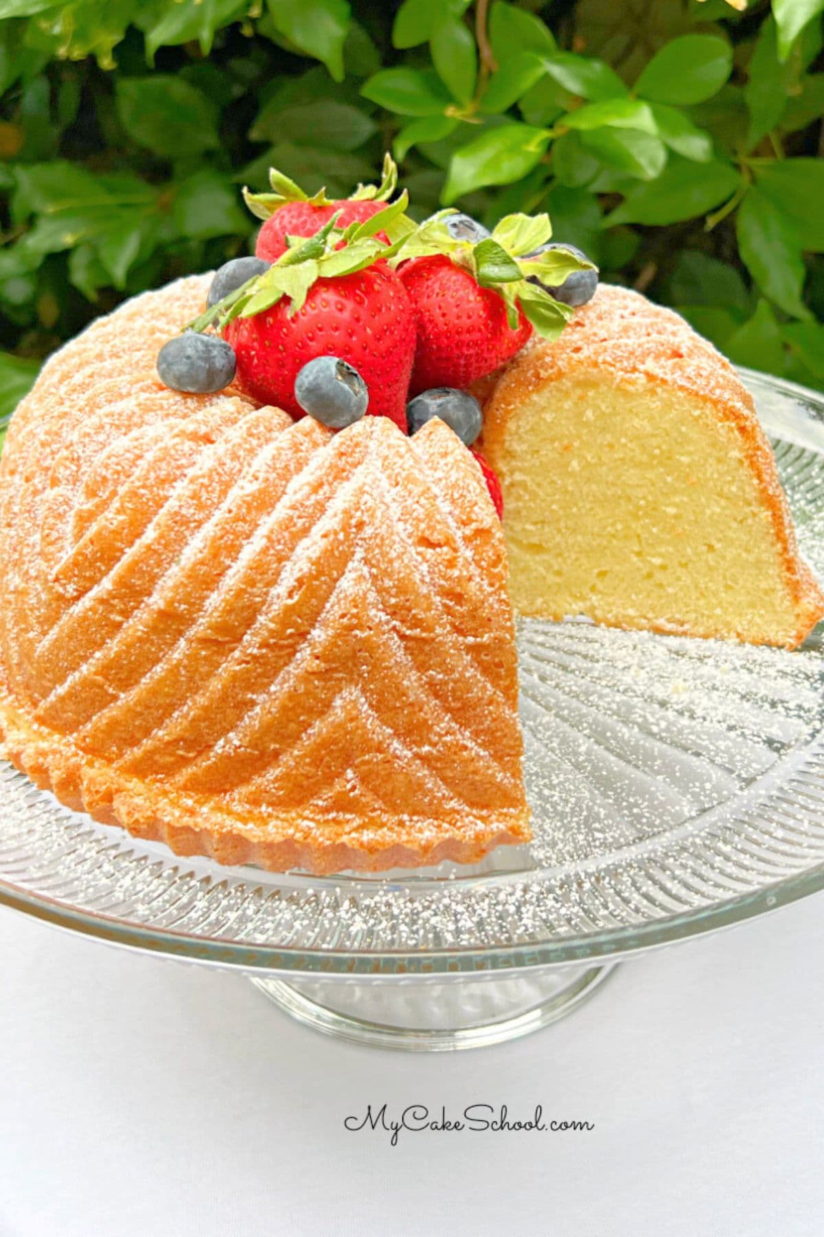 Sliced Vanilla Bundt Cake on a cake pedestal.