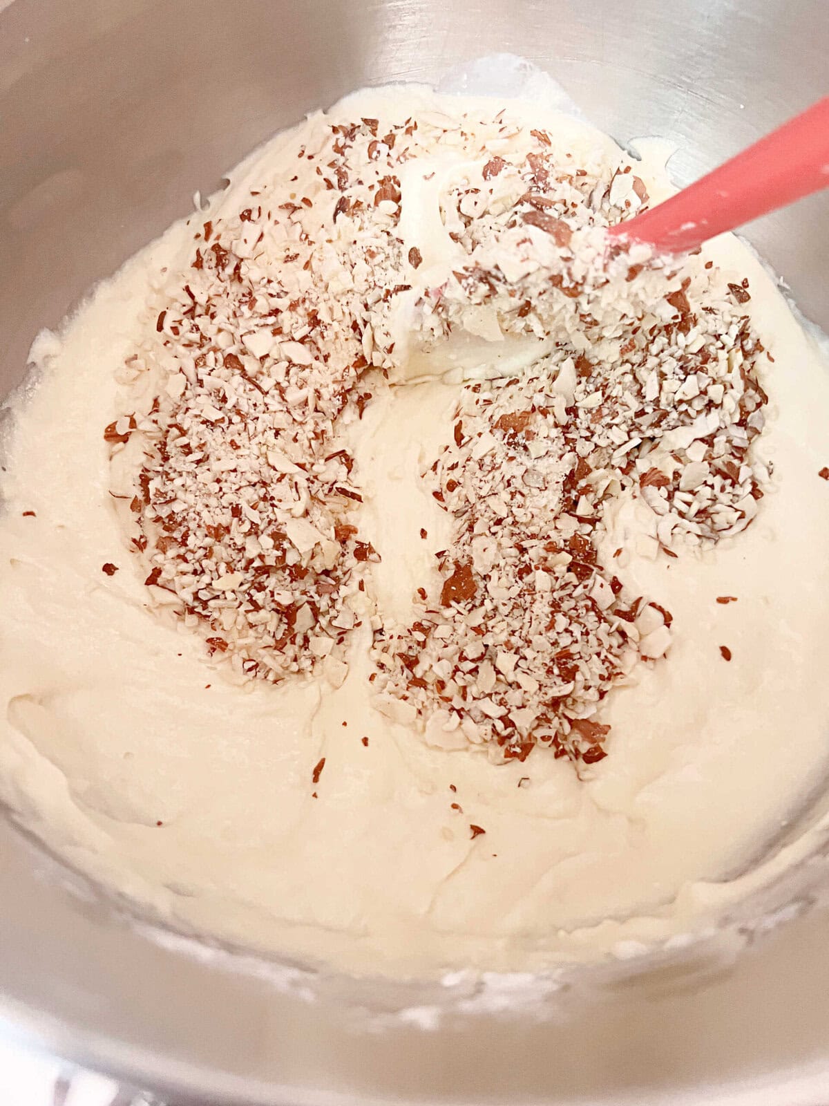 Almond Cake Batter in a bowl- stirring in the chopped almonds.