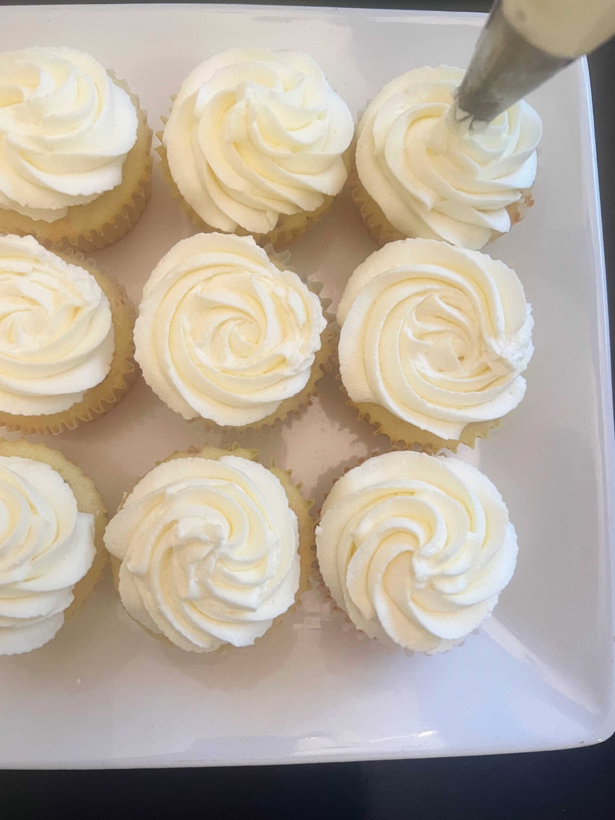 Frosting the almond cupcakes.