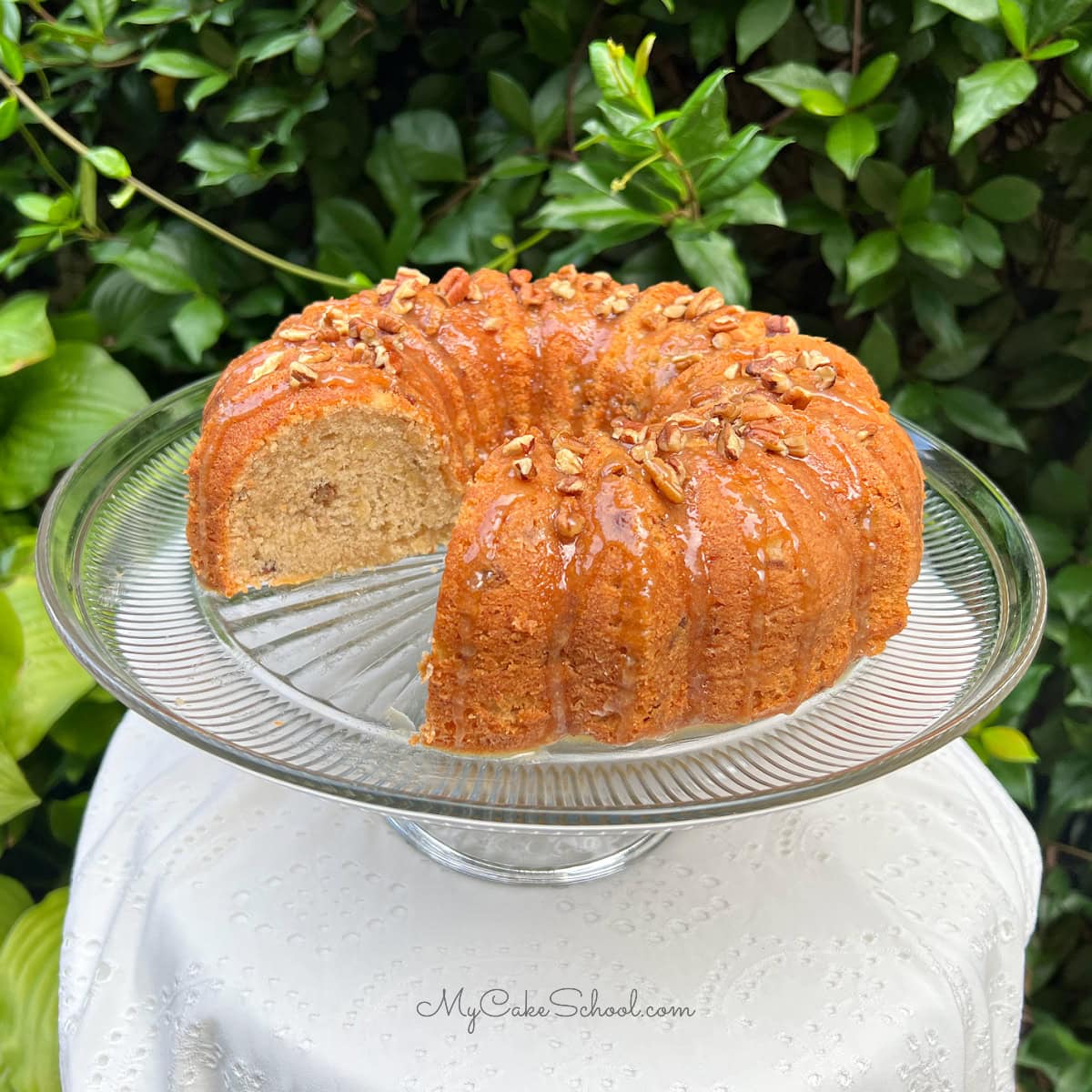 Banana Nut Bundt Cake, sliced, on a cake pedestal.