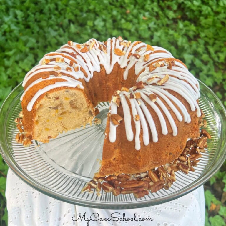 Peach pecan pound cake, sliced, on a cake pedestal.