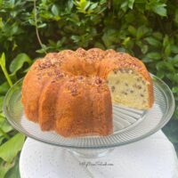 Coconut Pecan Pound Cake, sliced, on a cake pedestal.