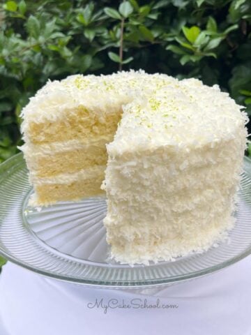 Key Lime Coconut Cake, Sliced, on a cake pedestal.