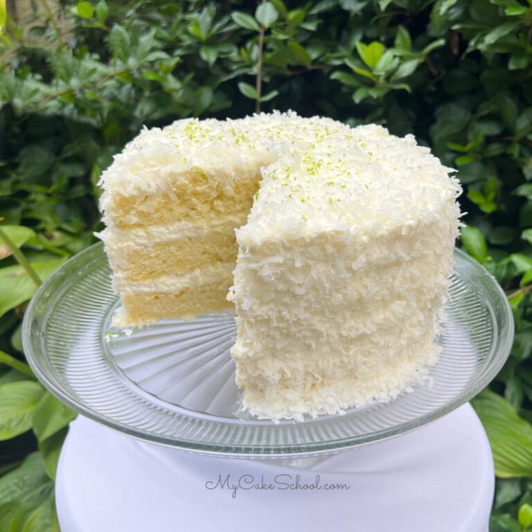 Key Lime Coconut Cake, Sliced, on a cake pedestal.