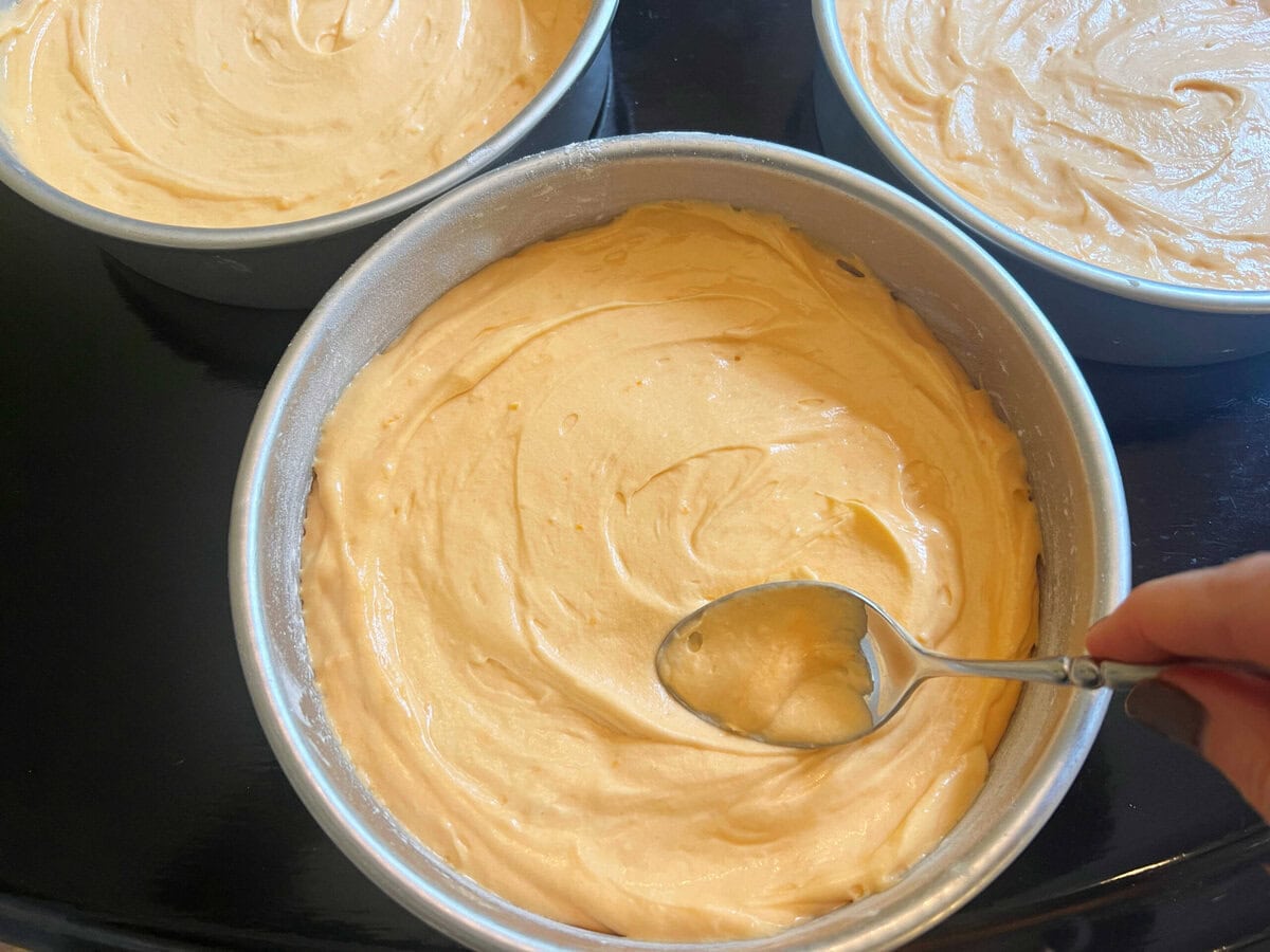 Orange velvet cake batter in pans.