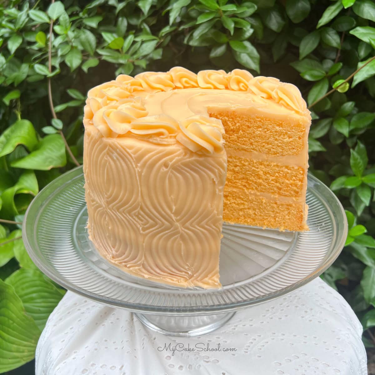 Orange Velvet Cake, sliced, on a cake pedestal.