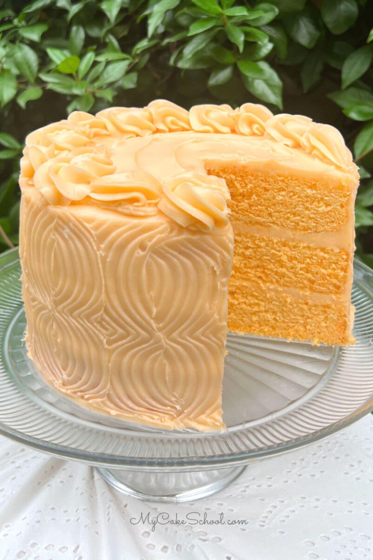 Orange Velvet Cake, sliced, on a cake pedestal.