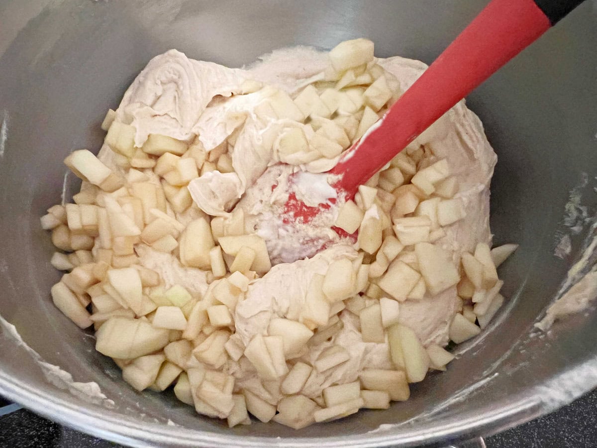 Folding apples into the cake batter.