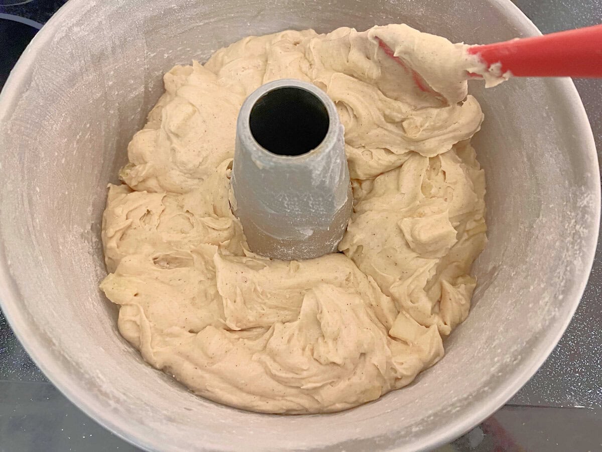 Scooping cake batter into prepared pan.