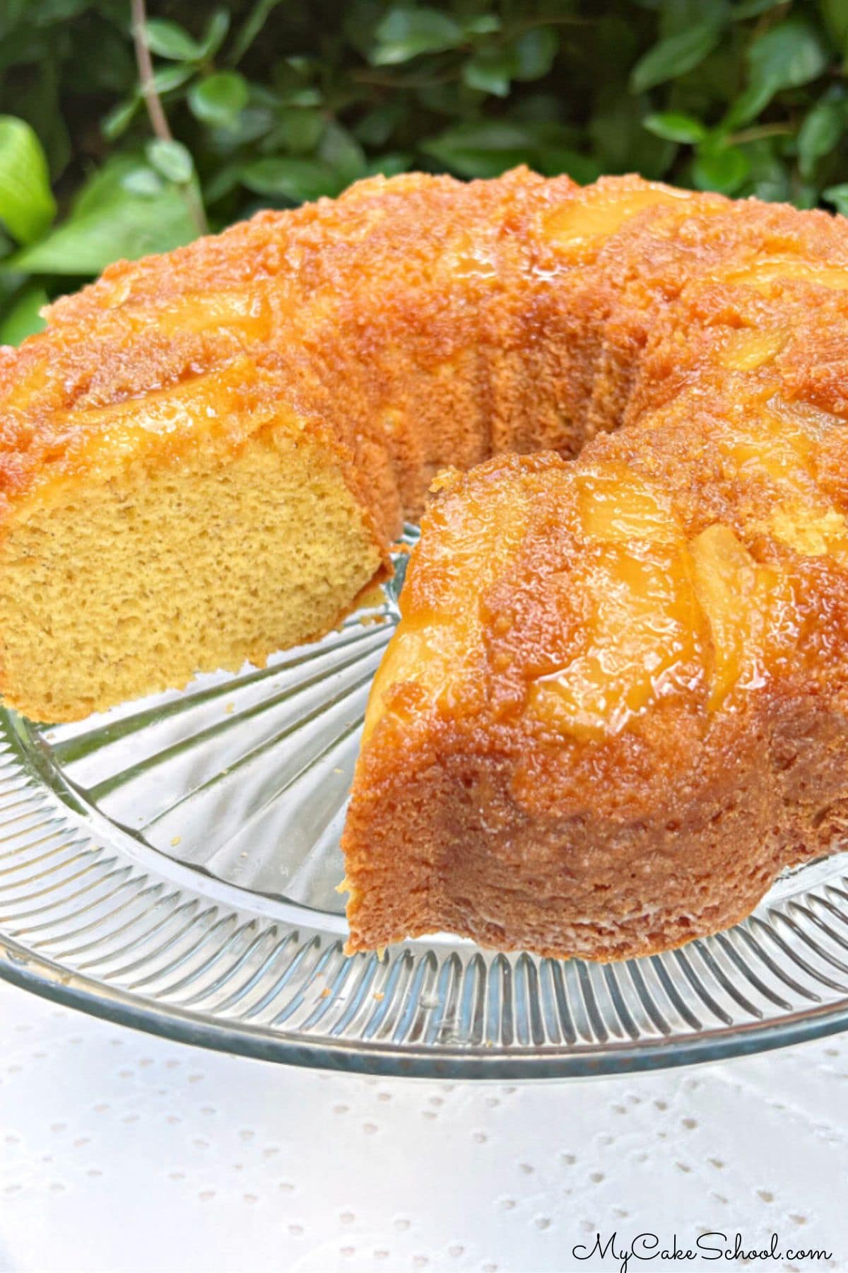 Apple Upside Down Cake, sliced, on a pedestal.