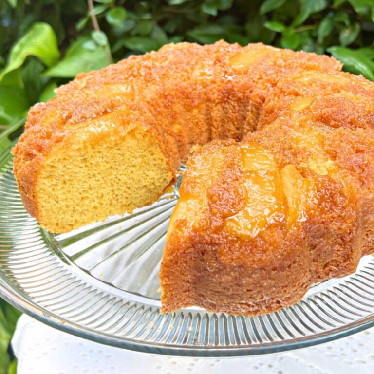 Apple Upside Down Cake, sliced, on a cake pedestal.