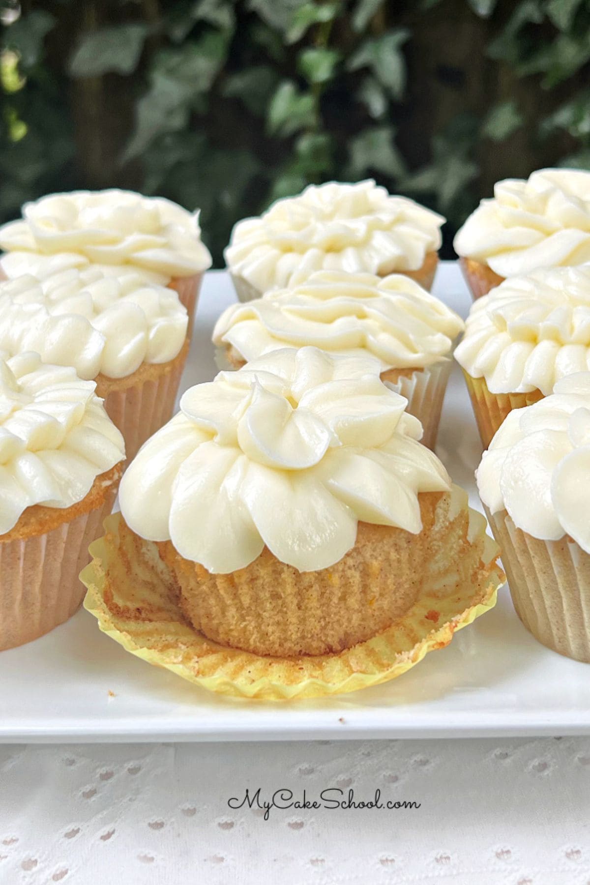 Spice cupcakes with orange cream cheese frosting on a platter.