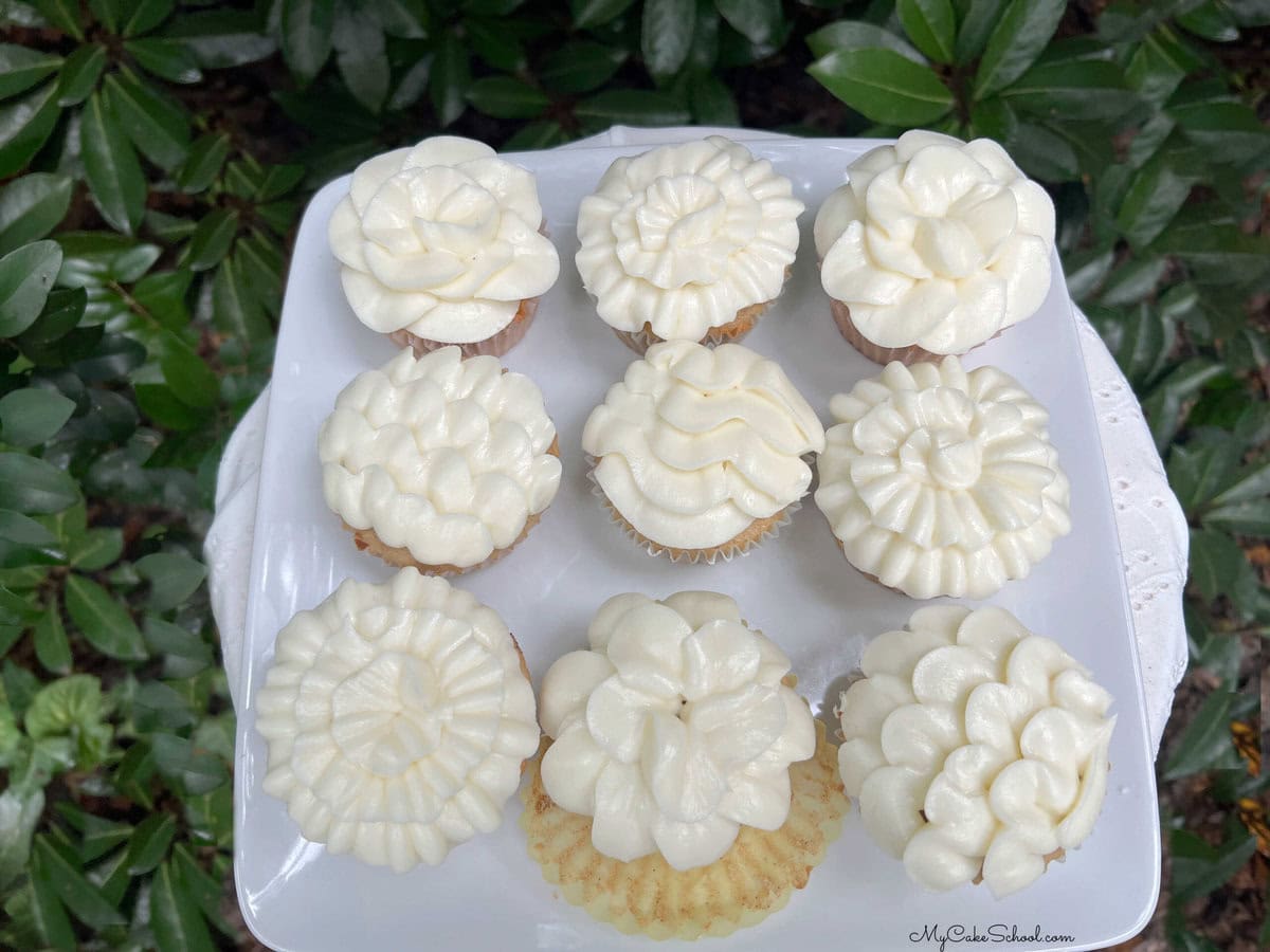 Spice cupcakes with orange cream cheese frosting on a platter.