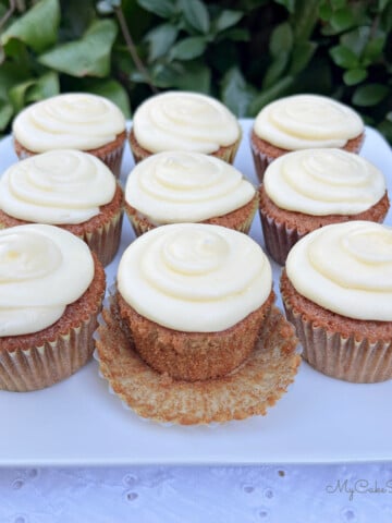 Gingerbread Cupcakes on a cake platter, frosted with cream cheese frosting.