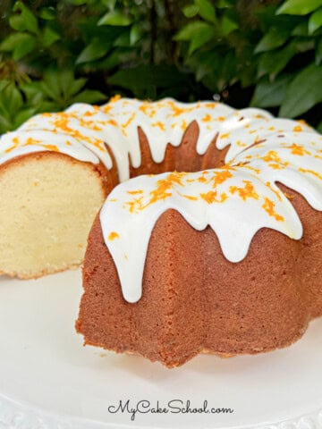 Orange Coconut Pound Cake, sliced, on a cake pedestal.