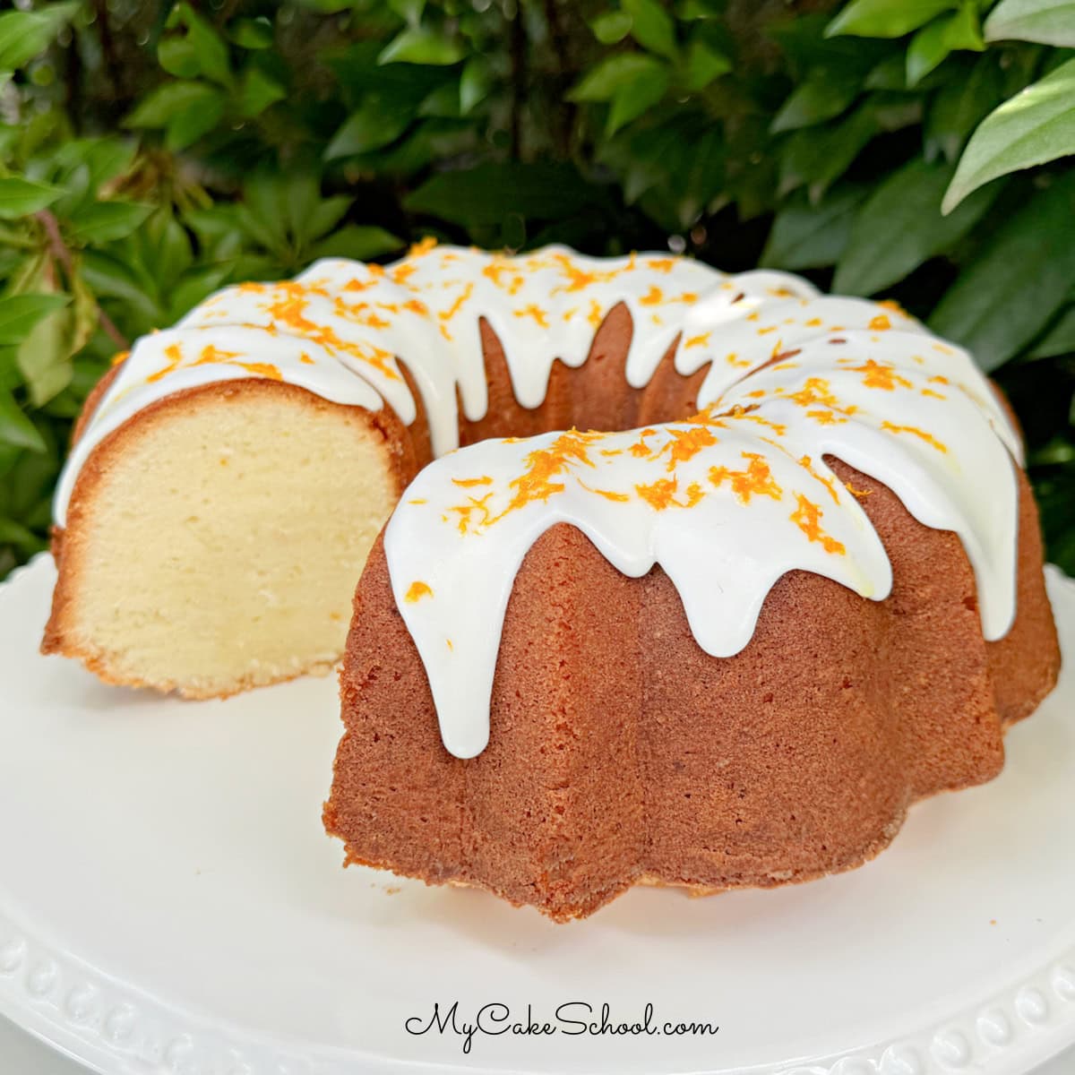 Orange Coconut Pound Cake, sliced, on a cake pedestal.