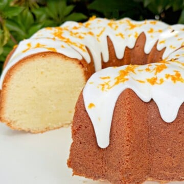 Orange Coconut Pound Cake, sliced, on a cake pedestal.