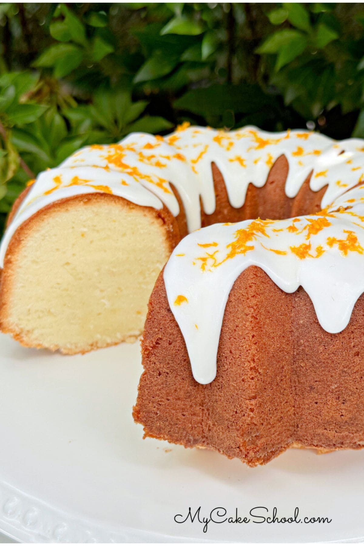 Orange Coconut Pound Cake, sliced, on a cake pedestal.