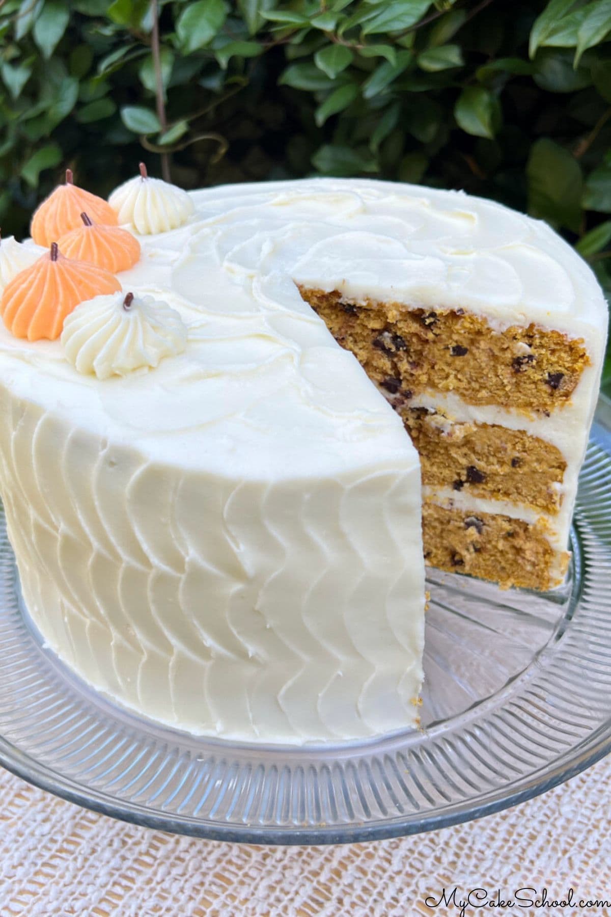 Pumpkin Chocolate Chip Cake, sliced, on a cake pedestal.