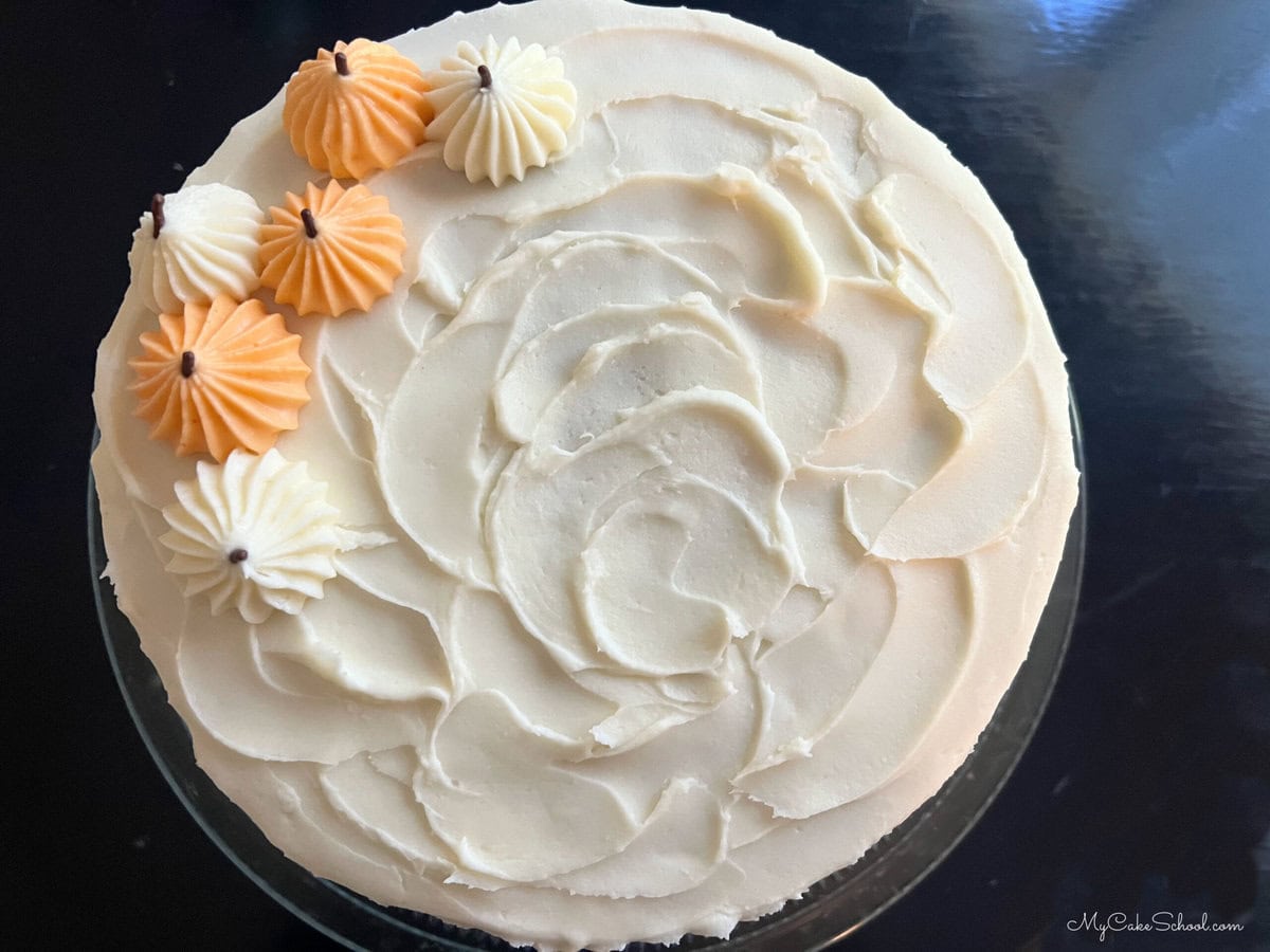 Top view of Pumpkin Chocolate Chip Cake with cream cheese frosting and piped pumpkins on top.