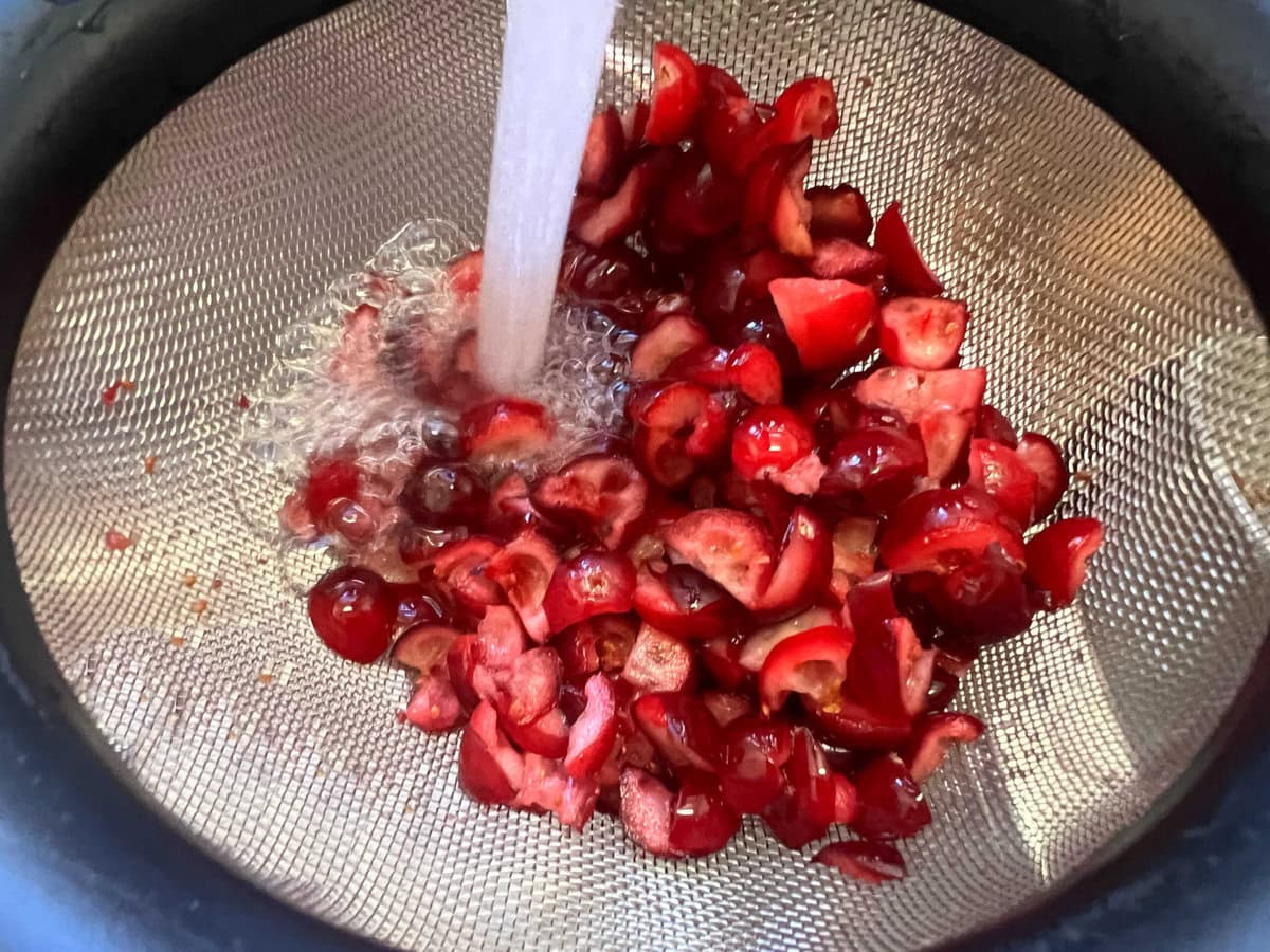 Rinsing cranberries in a strainer.