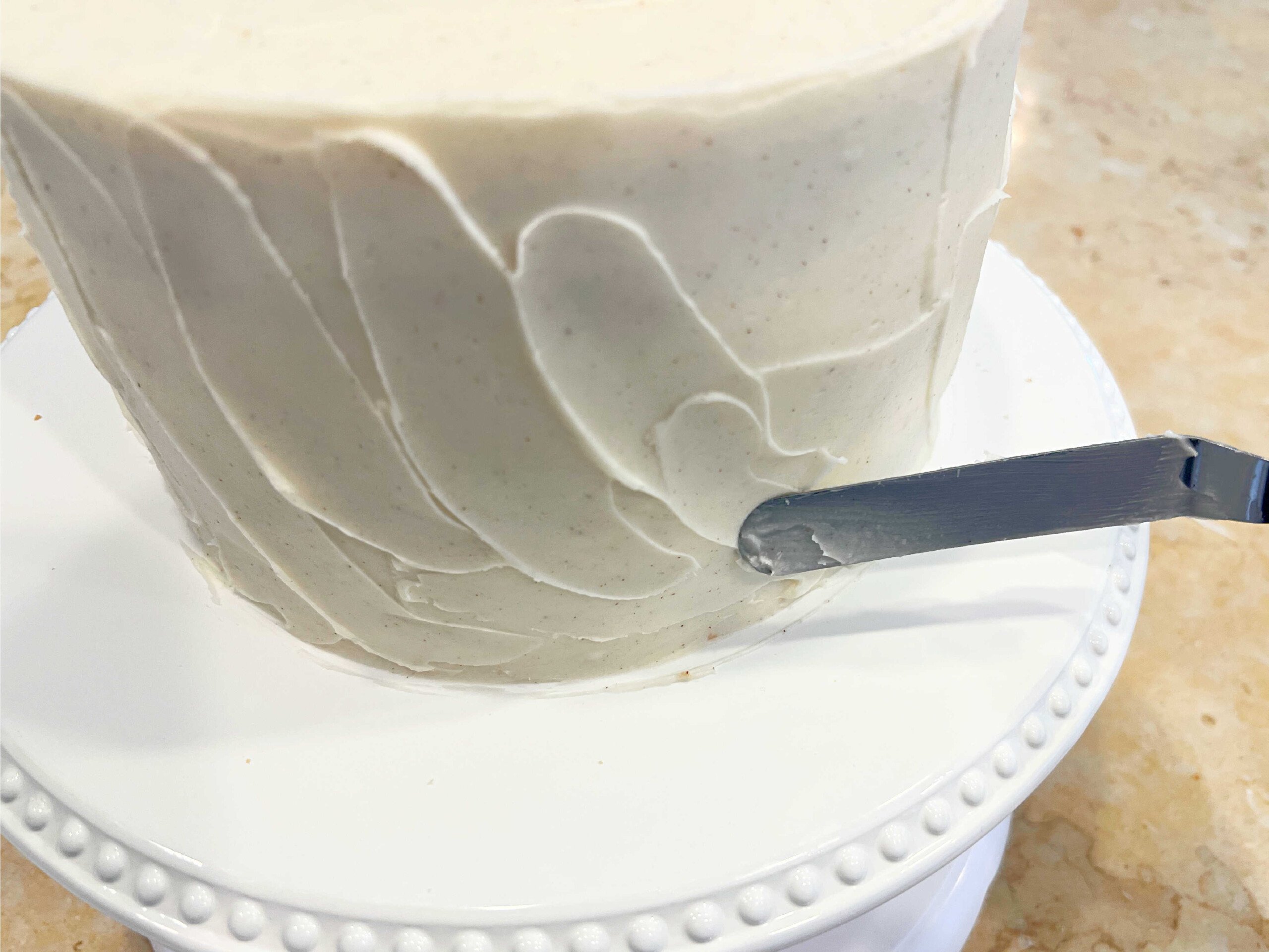 Adding texture to cake with a small rounded spatula.