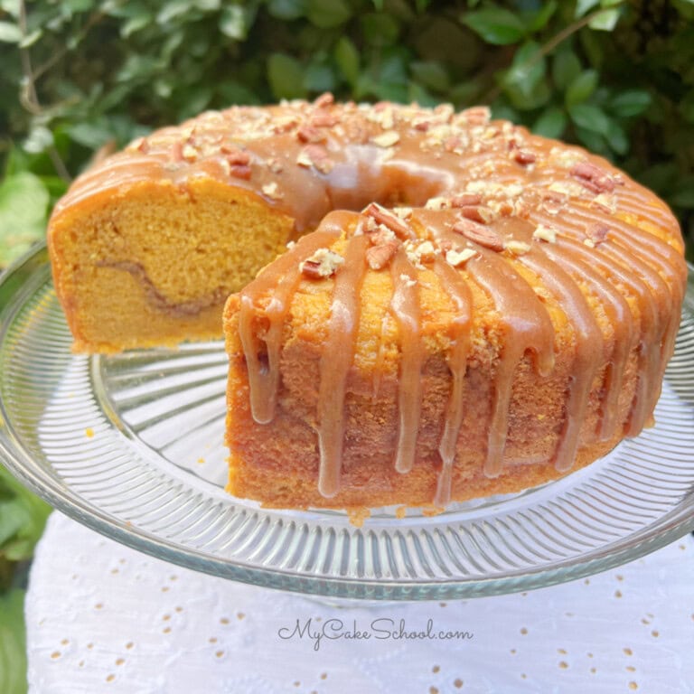 Pumpkin Snickerdoodle Bundt Cake, sliced, on a cake pedestal.