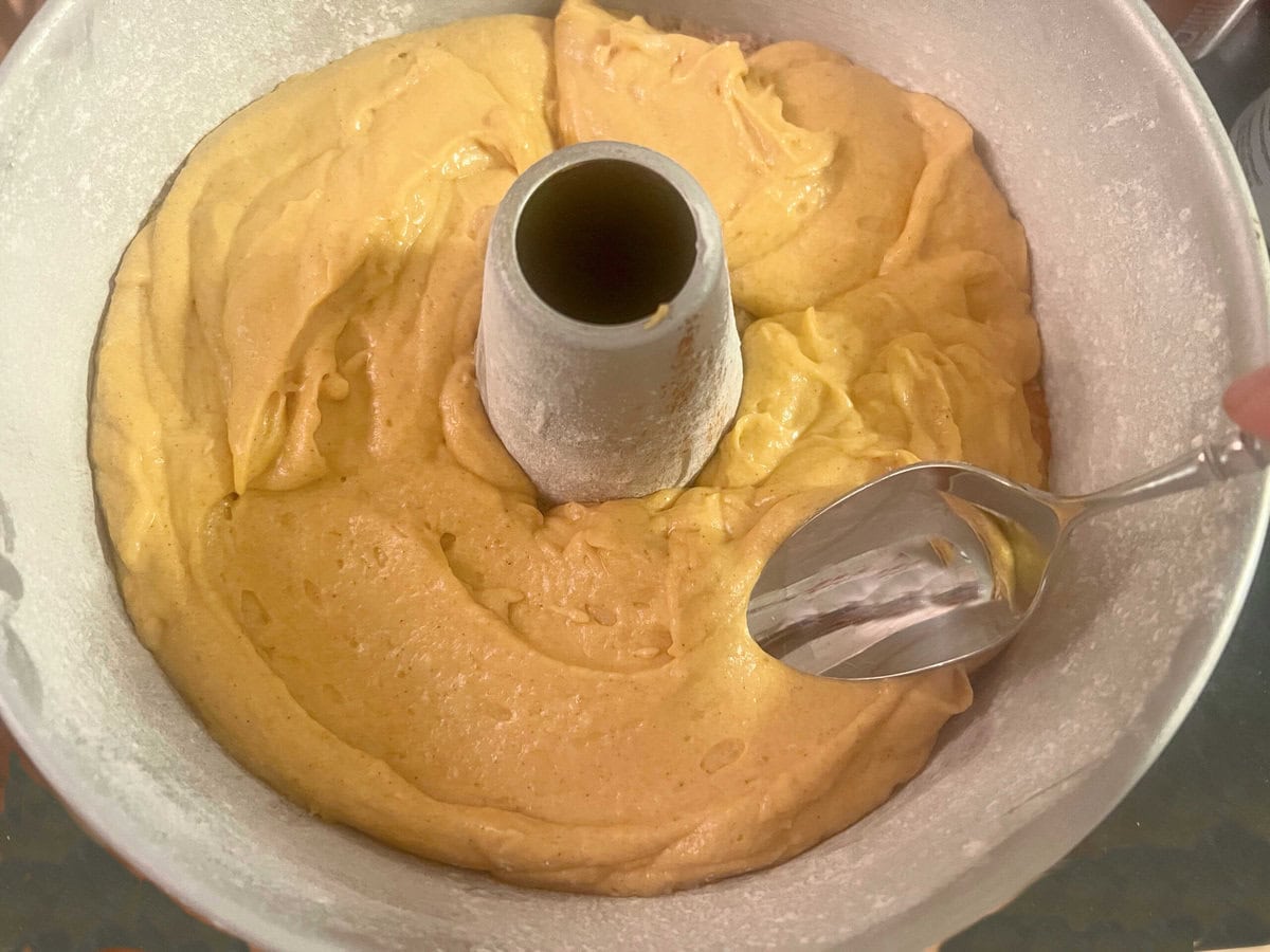 Smoothing the second half of the batter over the cinnamon and brown sugar mixture in the cake pan.