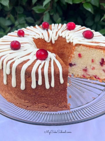 White Chocolate Cranberry Pound Cake, sliced, on a pedestal.