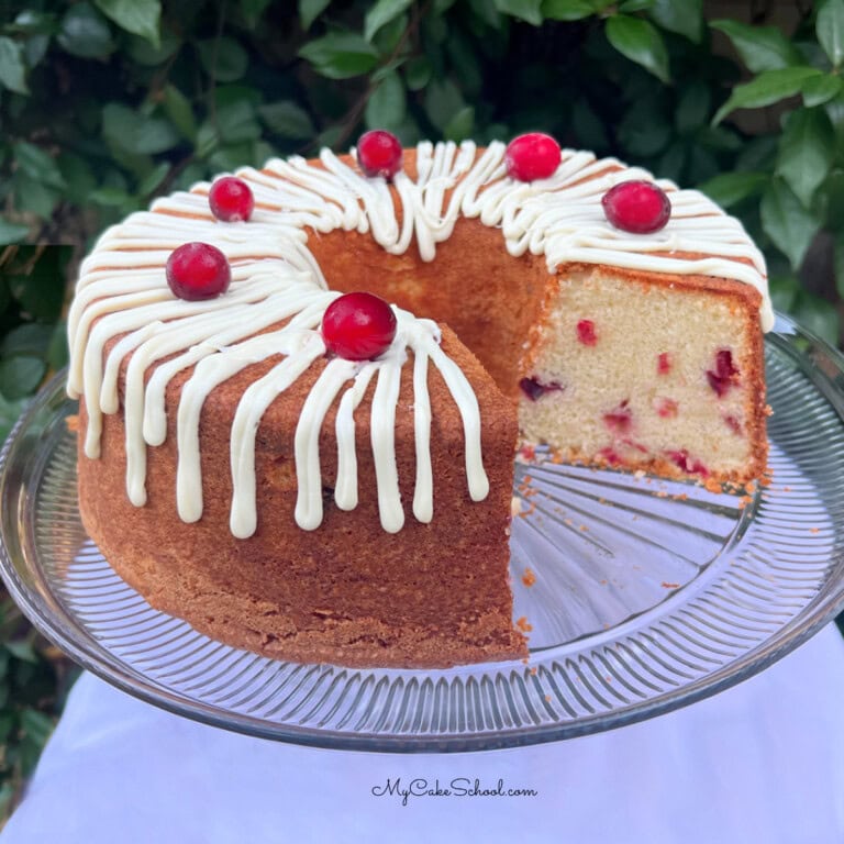 White Chocolate Cranberry Pound Cake, sliced, on a pedestal.