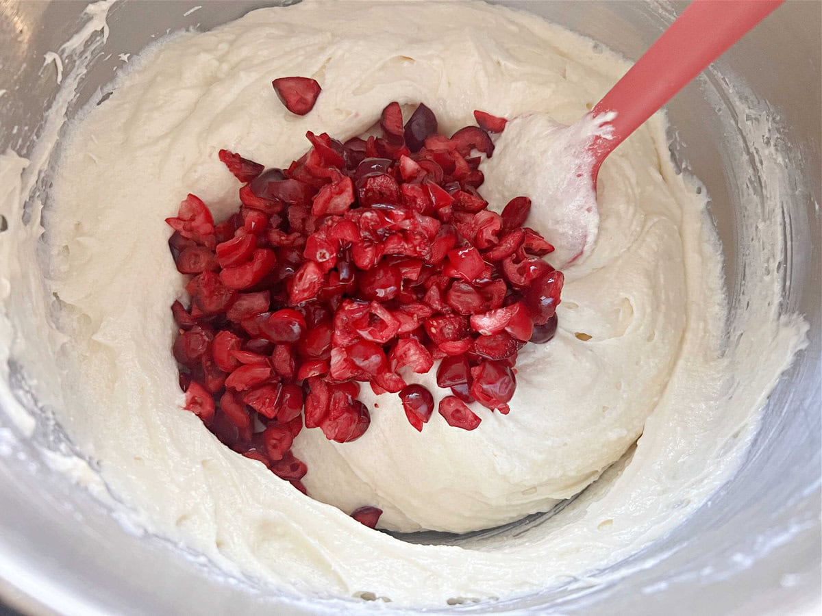 Stirring the cranberries into the white chocolate pound cake batter.