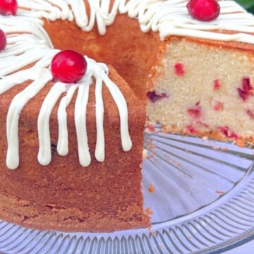 White Chocolate Cranberry Pound Cake, sliced, on a pedestal.