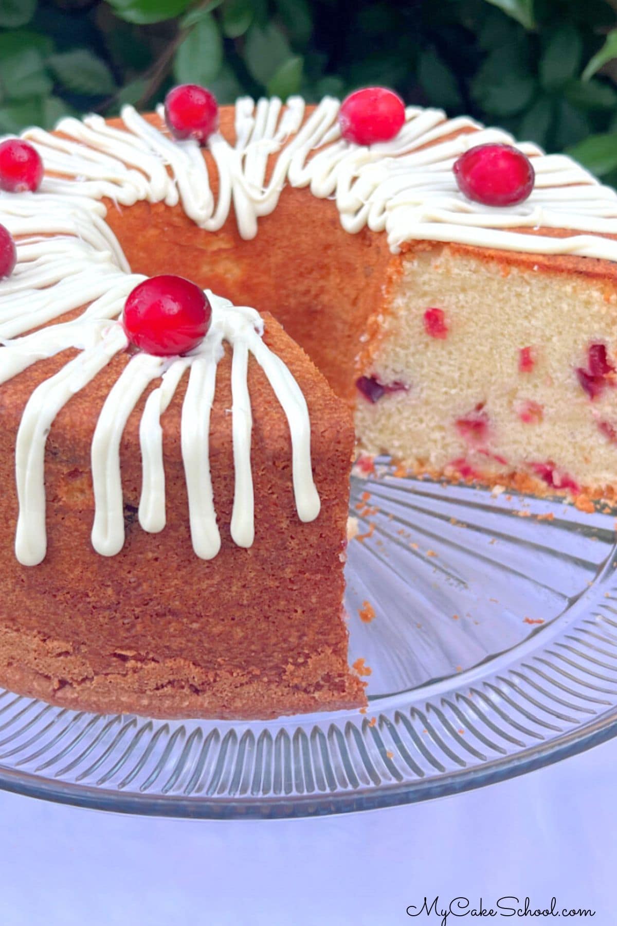 White Chocolate Cranberry Pound Cake, sliced, on a pedestal.