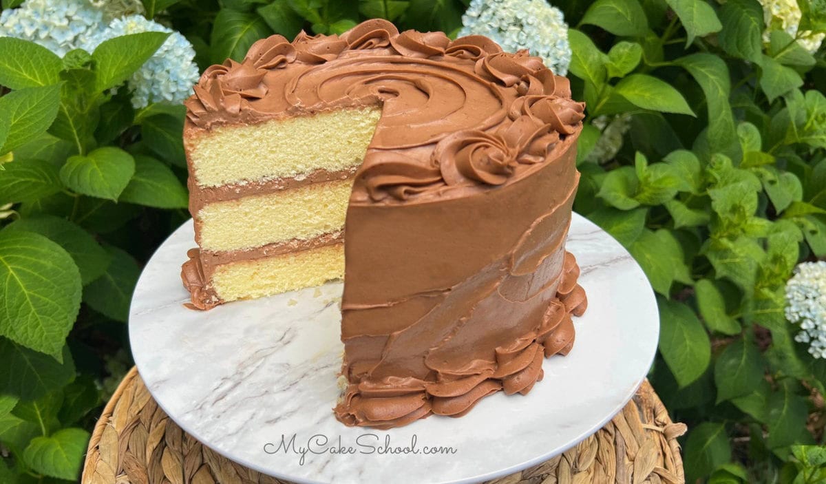 Yellow Velvet Cake, sliced, on a cake pedestal.