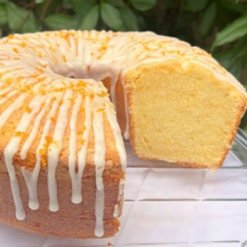 Orange pound cake, sliced, on a cake pedestal.